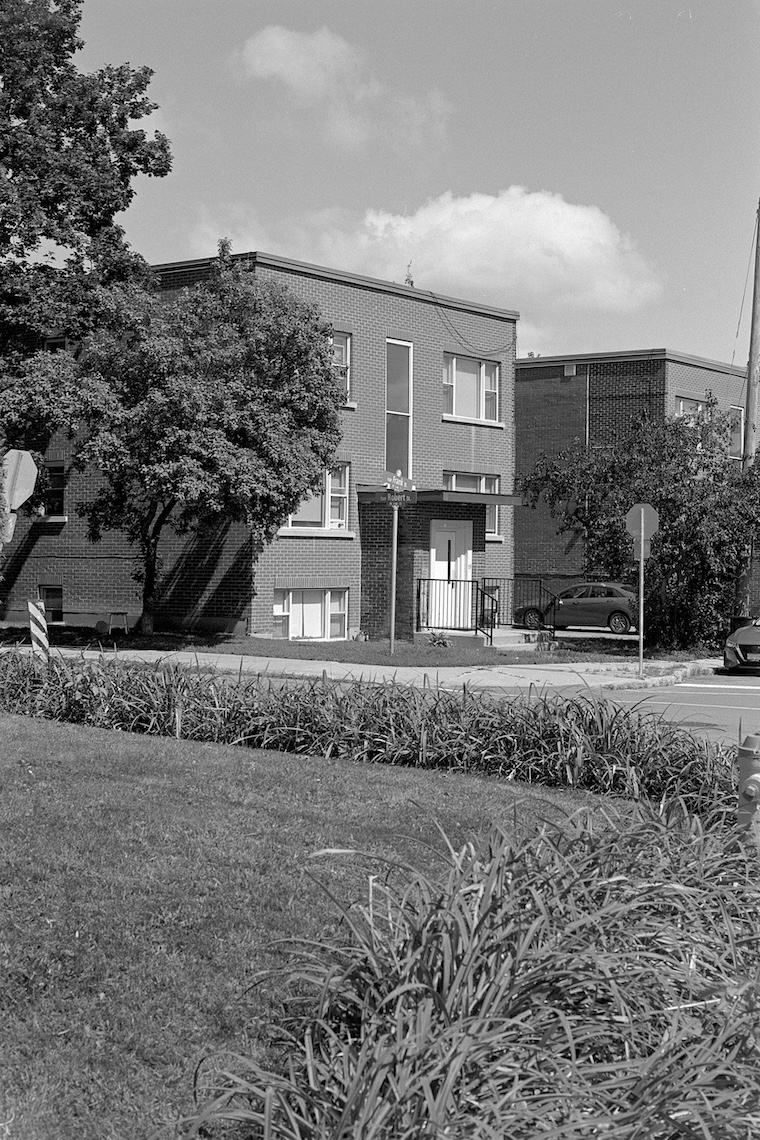 Photo of a six-plex apartment, as seen across the corner lot of a neighbouring home. Click for full size.
